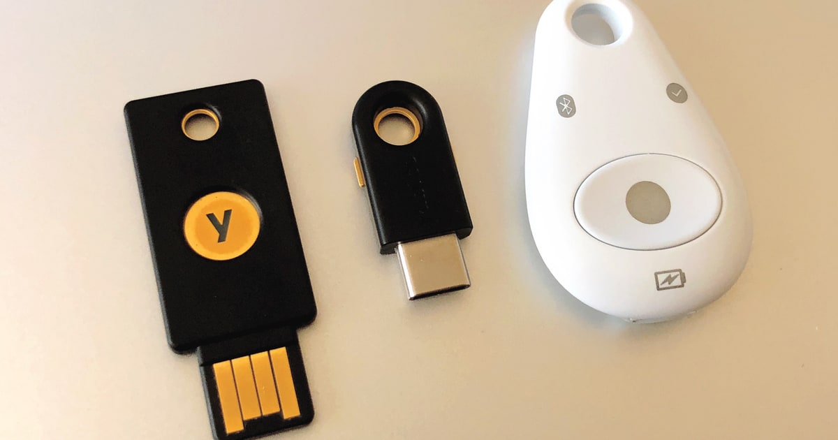 Two Yubico USB security keys and a Feitian security token used for hardware-based authentication.
